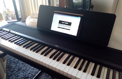 A digital piano with the Pianoforall Course displayed on a tablet