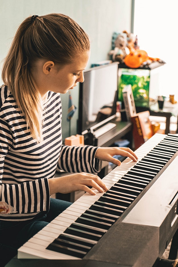 woman learning how to play the piano with Skoove piano learning app